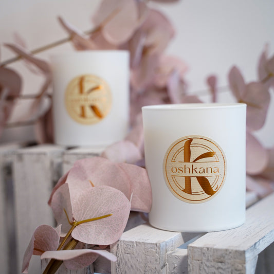 two oshkana vegan soy wax candles peony musk around rose gold leaves