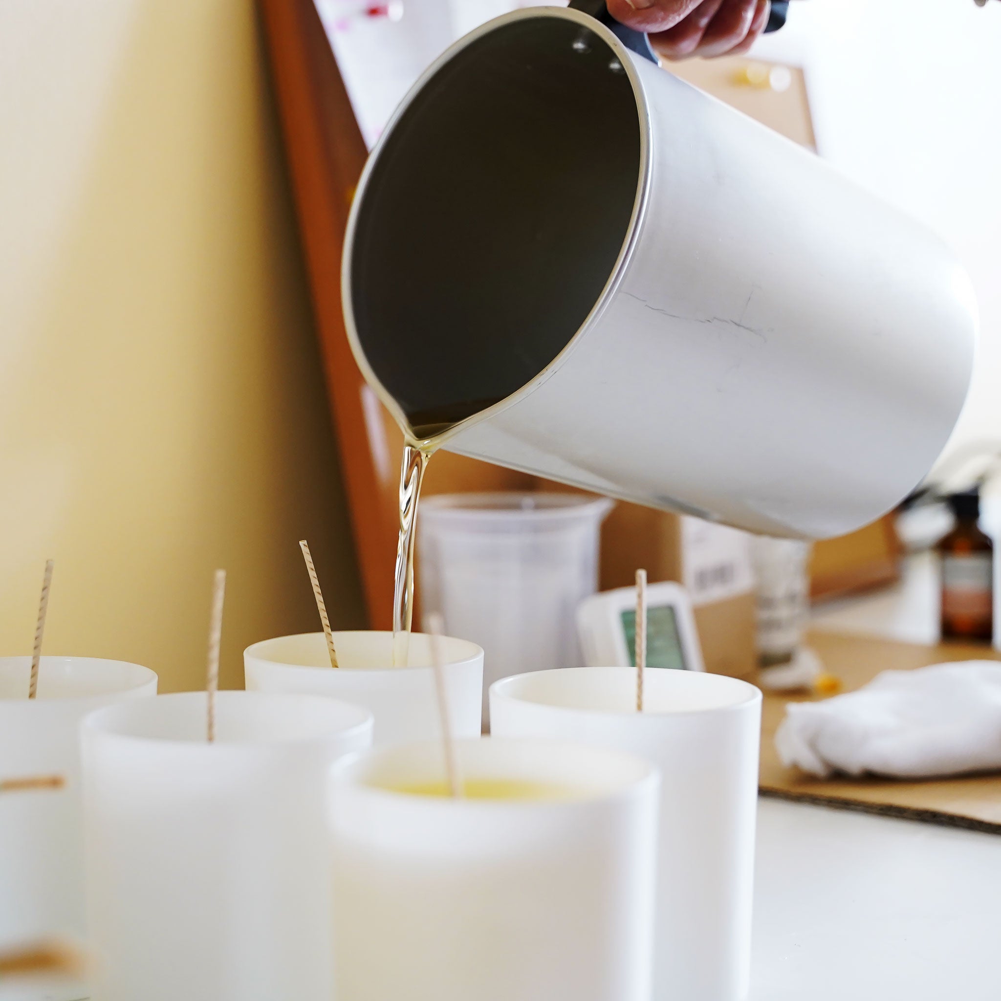 pouring wax onto candle vessels